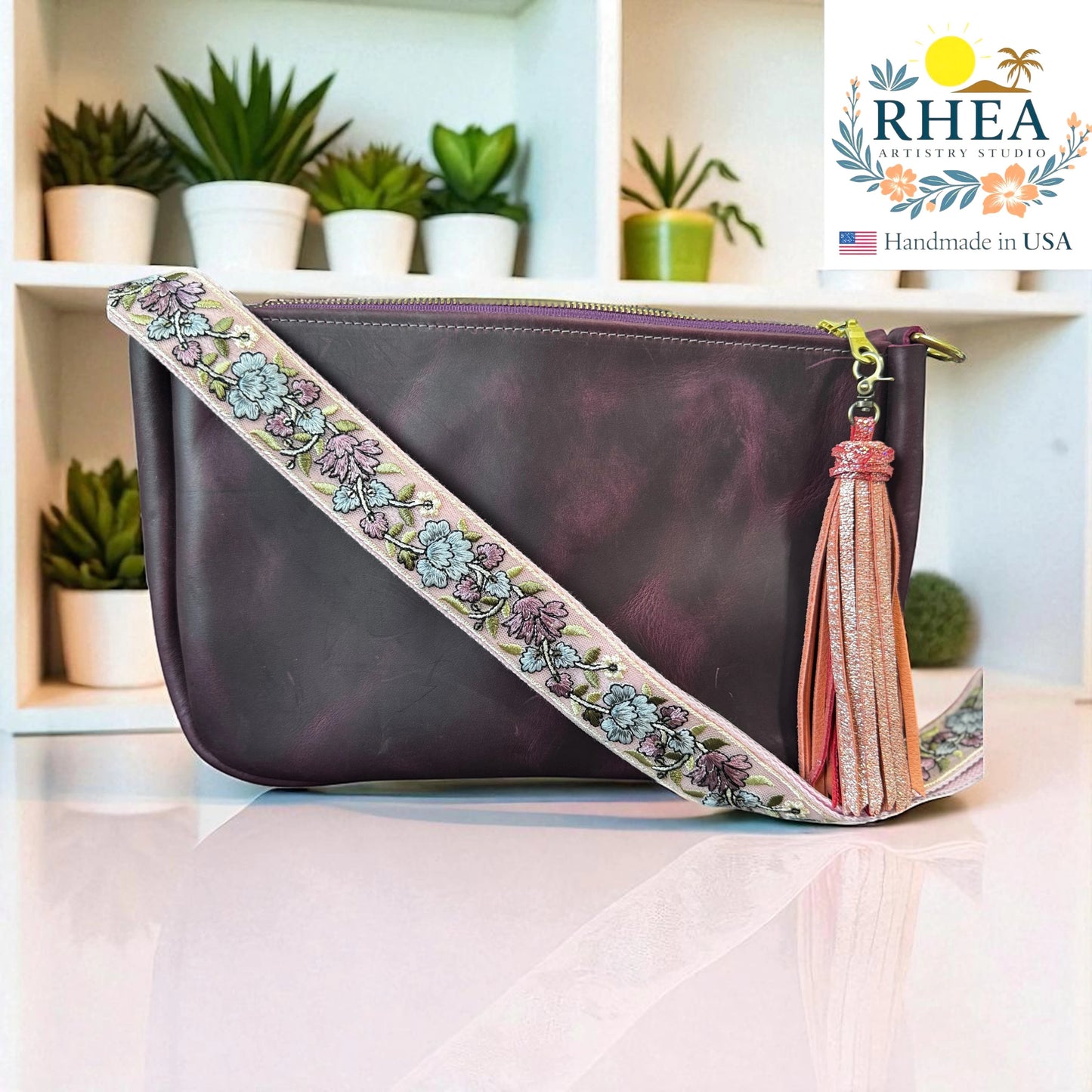 Rhea Artistry Studio lavender and silver embroidered crossbody strap with floral detail on a purple leather bag.