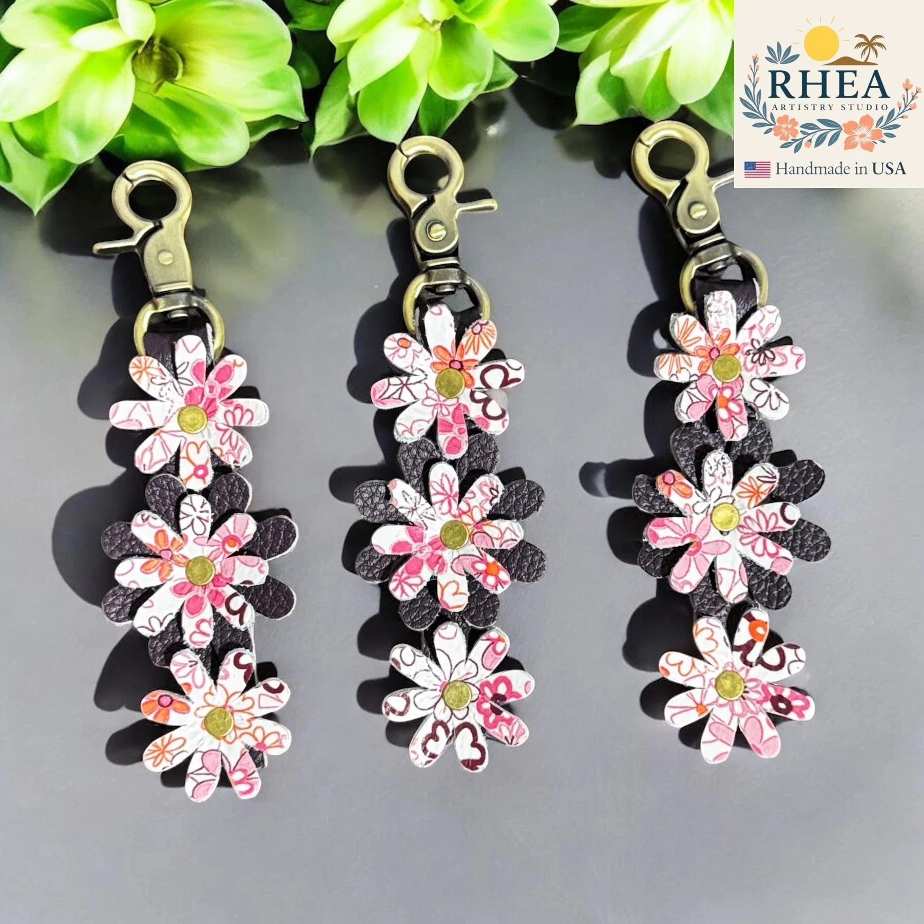 Rhea Artistry Studio layered leather daisy charm with pink floral print and antique brass lobster clasp, 5 inches long.