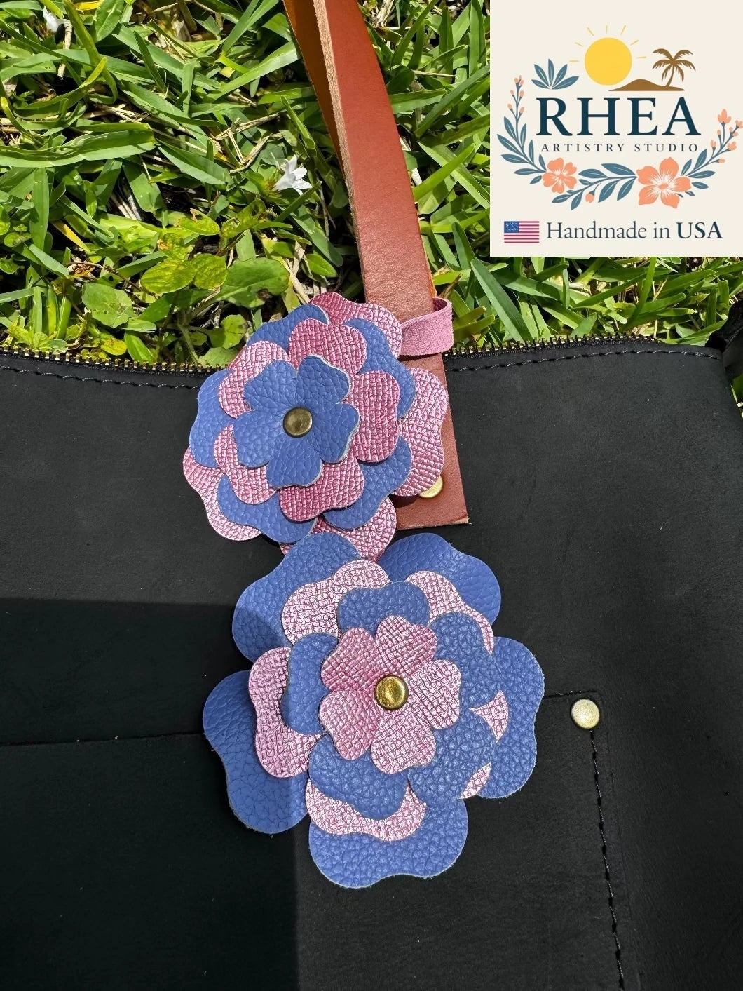 Rhea Artistry Studio double leather flower charm in Blue Bell and Barbie Pink, handcrafted from full-grain leather with brass rivets.