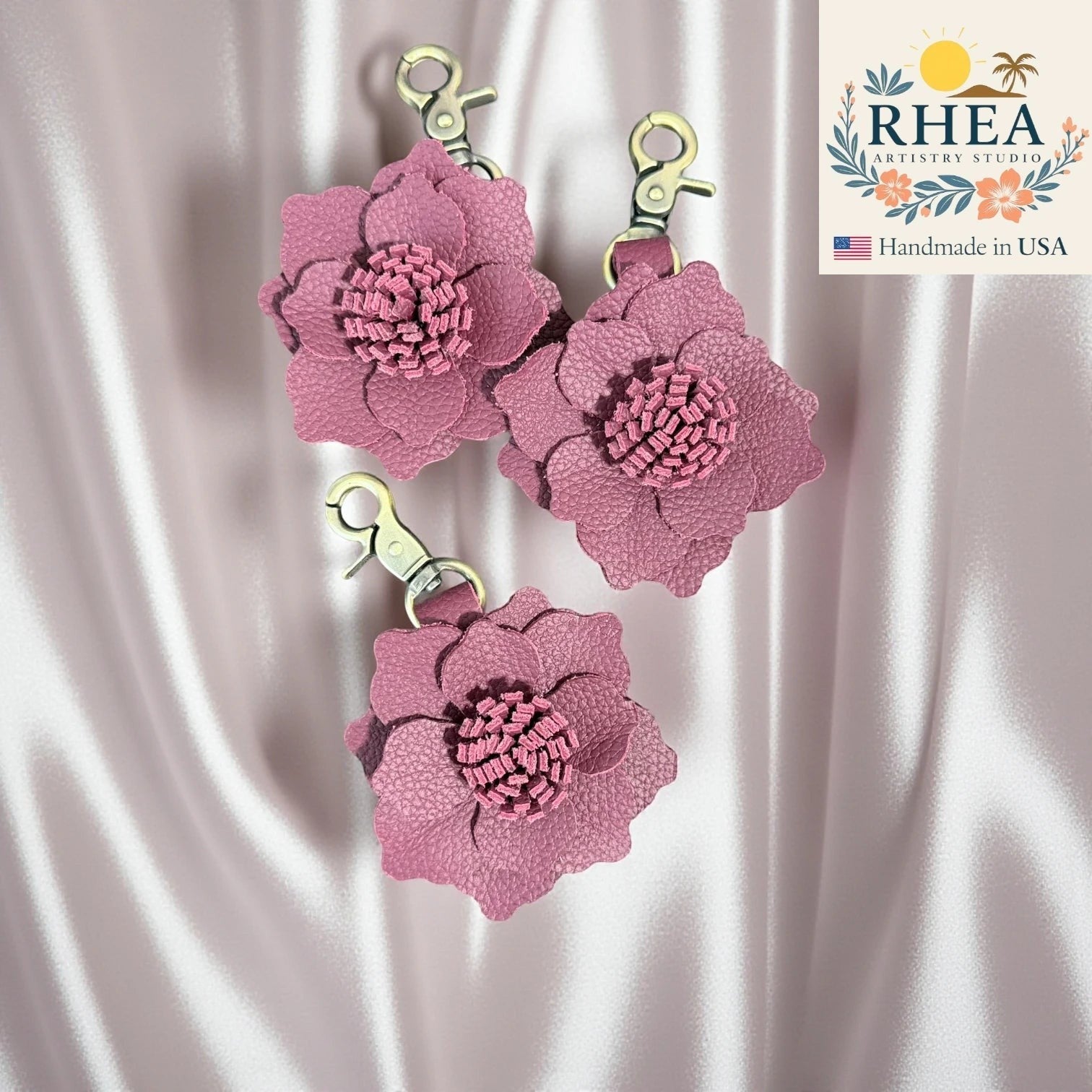 Rhea Artistry Studio dusty rose leather flower charm with textured center and gold clasp, handcrafted for bags and keys.