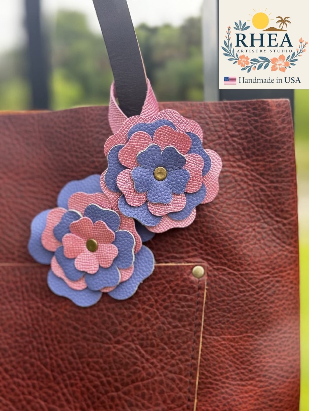 Rhea Artistry Studio double leather flower charm in Barbie Pink and Blue Bell, accented with brass rivets.