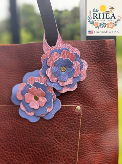 Rhea Artistry Studio double leather flower charm in Barbie Pink and Blue Bell, accented with brass rivets.