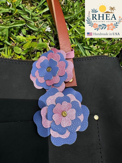 Rhea Artistry Studio double leather flower charm in Barbie Pink and Blue Bell, accented with brass rivets.