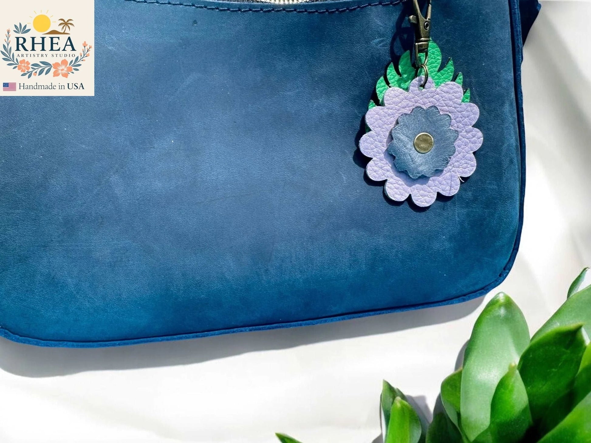 Rhea Artistry Studio blue leather monstera leaf and flower charm with brass clasp, 3 inches long.