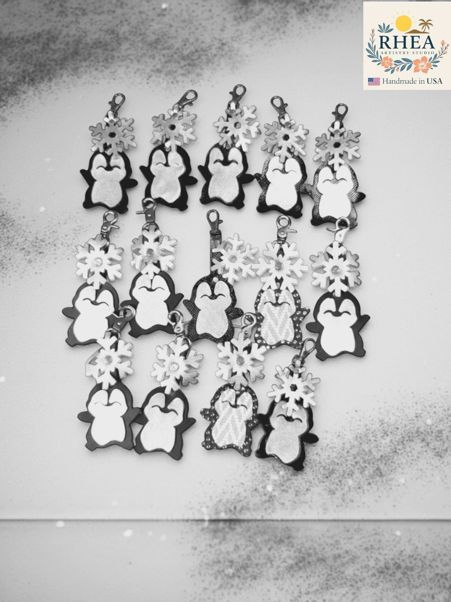 Rhea Artistry Studio handmade black and white leather penguin charms with snowflake details, perfect for winter purses.