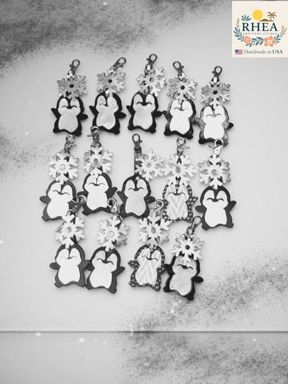 Rhea Artistry Studio handmade black and white leather penguin charms with snowflake details, perfect for winter purses.