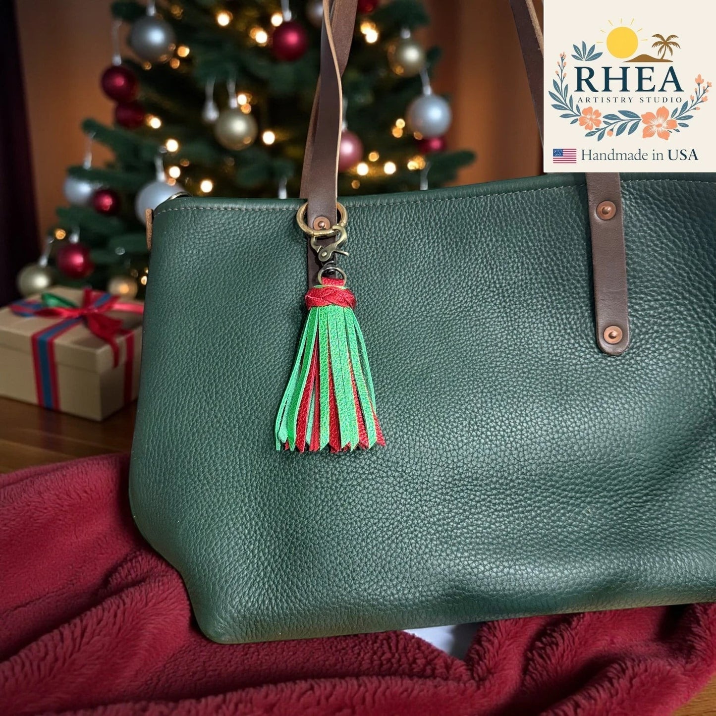 Rhea Artistry Studio handmade green and red leather tassel bag charm with antique brass lobster clasp.