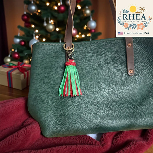 Rhea Artistry Studio handmade green and red leather tassel bag charm with antique brass lobster clasp.