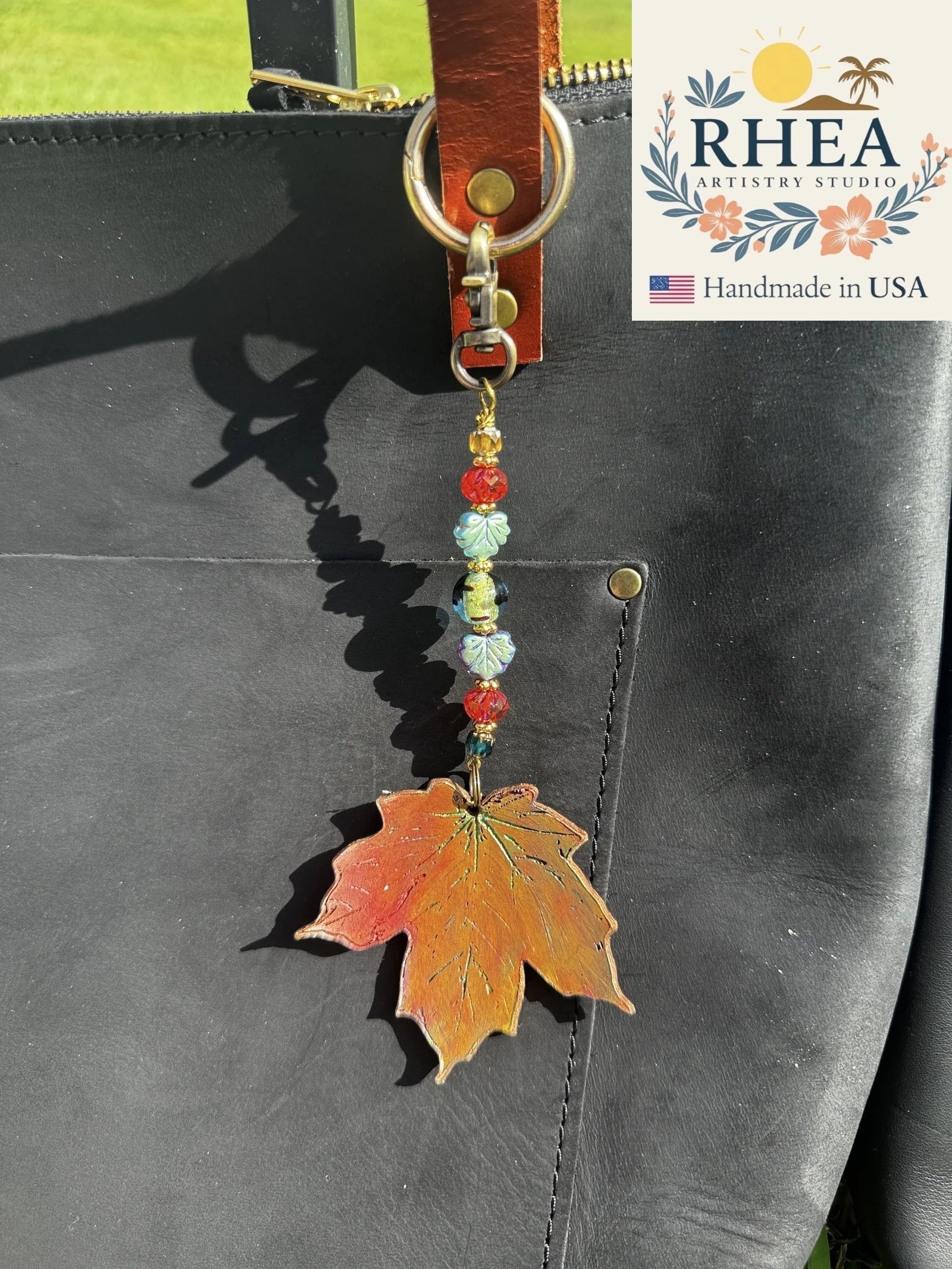 Rhea Artistry Studio OOAK maple leaf charm on vegetable-tanned leather with Czech glass beads and brass hardware.