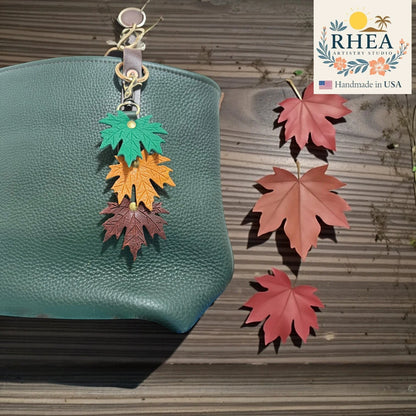 Rhea Artistry Studio layered maple leaf leather bag charm in green, orange, and brown with brushed brass hardware.