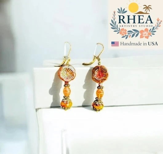 Rhea Artistry Studio mustard hibiscus drop earrings with brass accents, approx. 1.5-2 inches long, handcrafted in USA.