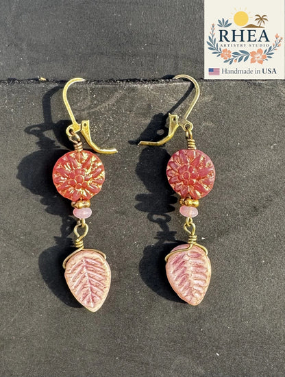 Rhea Artistry Studio pink dahlia floral drop earrings with leafy accents and brass hardware.