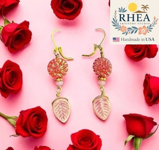 Rhea Artistry Studio pink dahlia floral glass bead drop earrings with leafy accents and brass hardware, approx. 2 inches long.