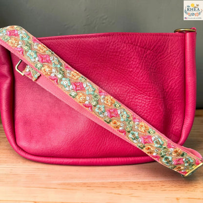 Rhea Artistry Studio blush pink crossbody strap with green, orange, and pink diamond floral embroidery, 2-inch width, adjustable length.