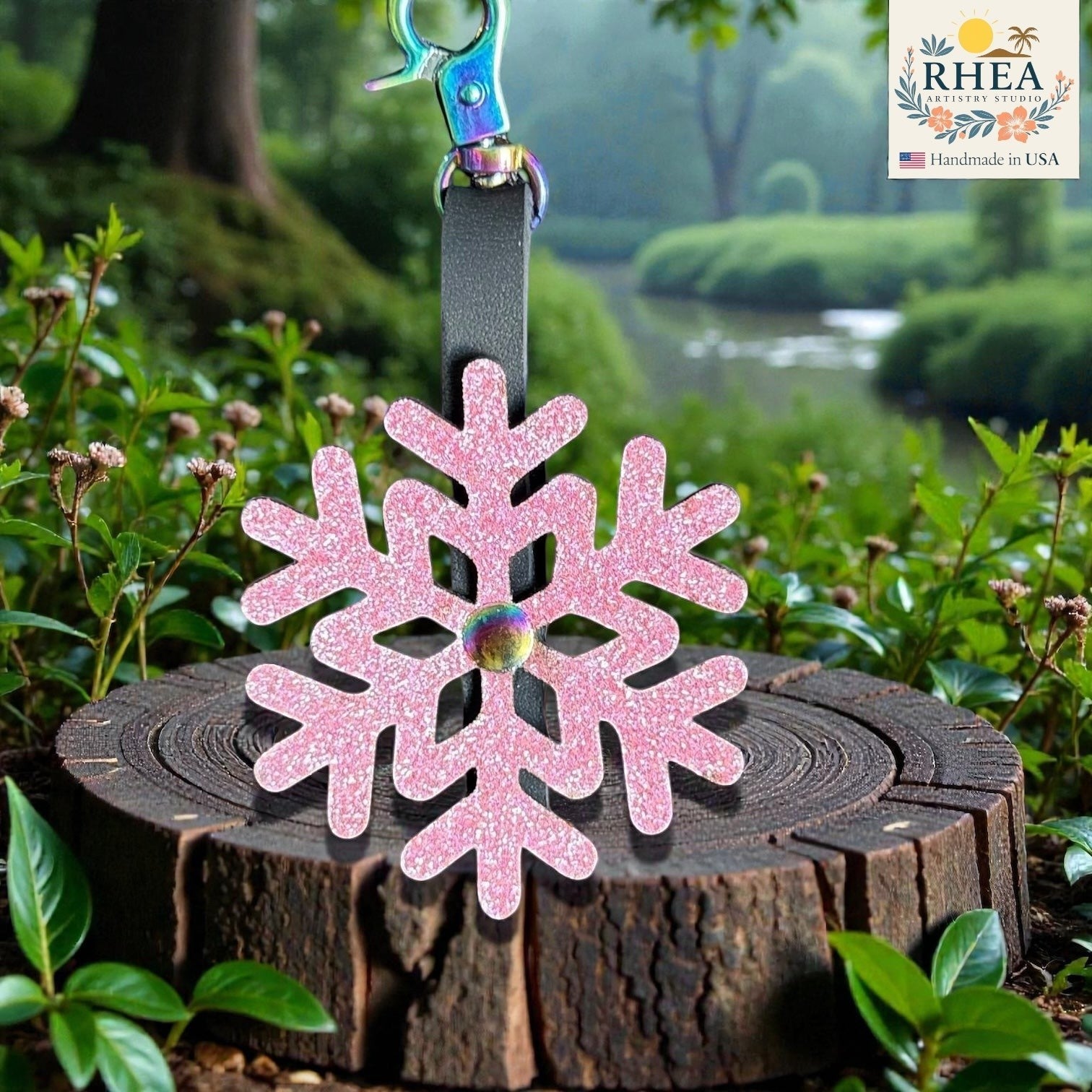 Rhea Artistry Studio pink glitter snowflake leather charm with rainbow hardware, handmade in USA.