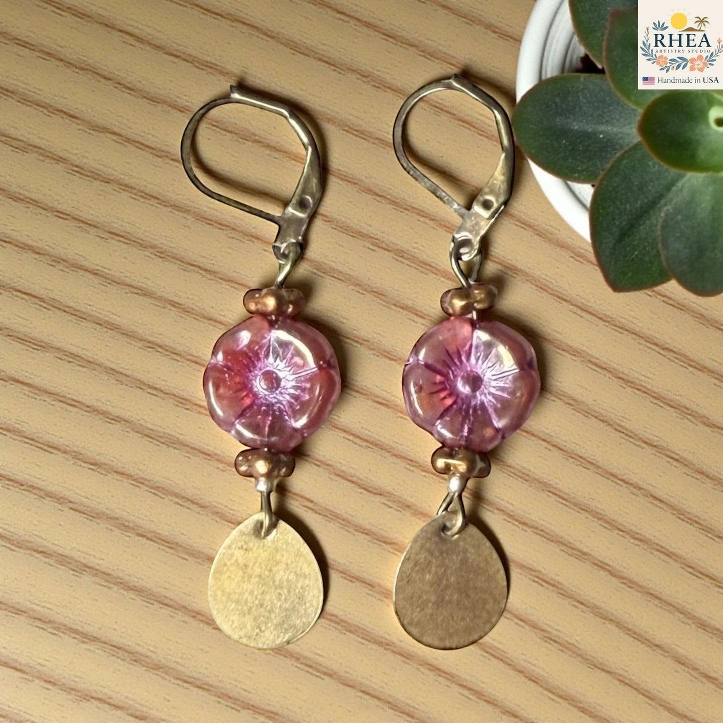 Rhea Artistry Studio pink hibiscus glass bead drop earrings with brass accents and leverback hooks.