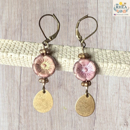 Rhea Artistry Studio pink glass hibiscus flower drop earrings with brass accents and leverback hooks.