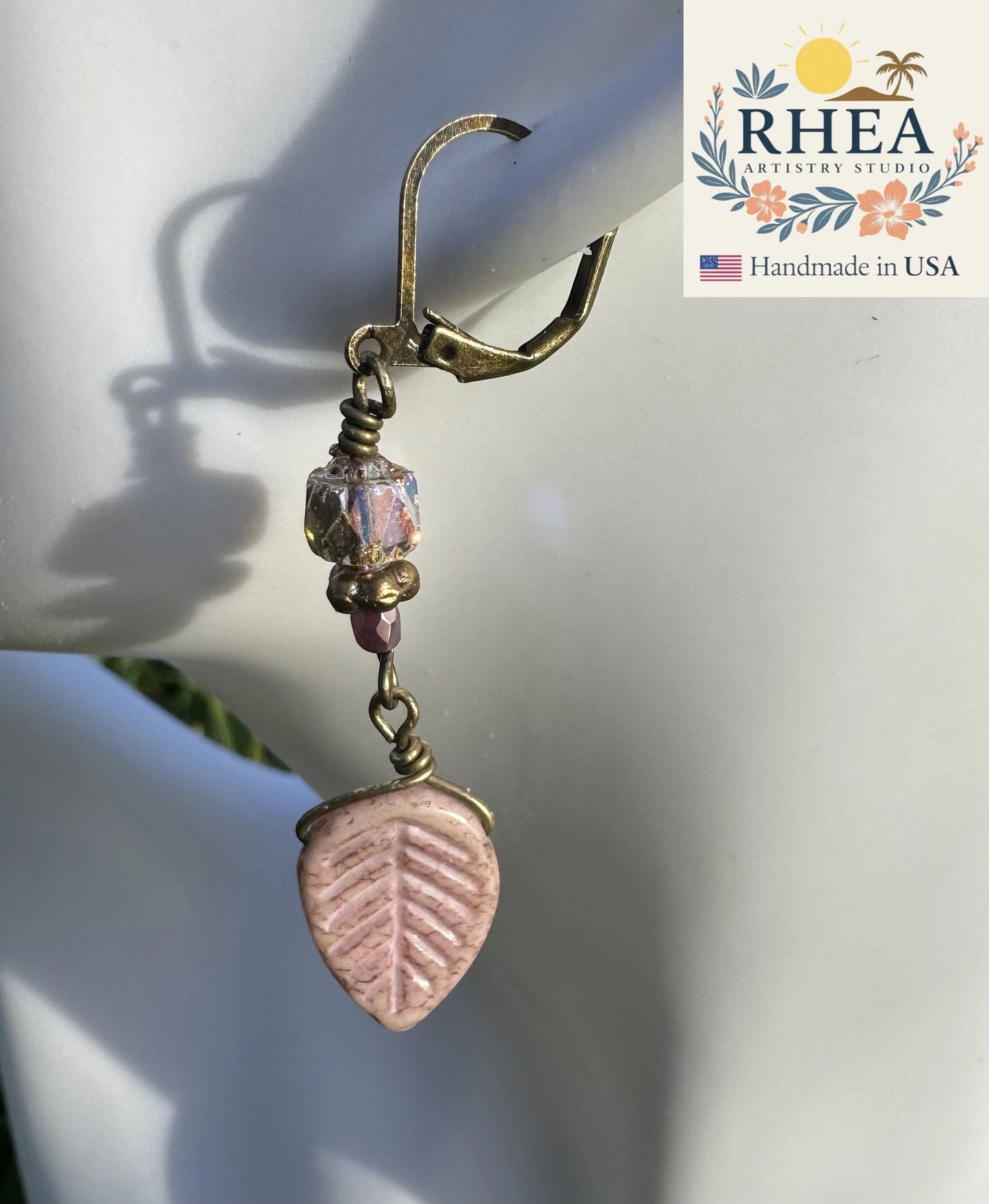Rhea Artistry Studio pink leaf Czech glass earrings with bronze accents and brass hardware, approx. 2 inches long.
