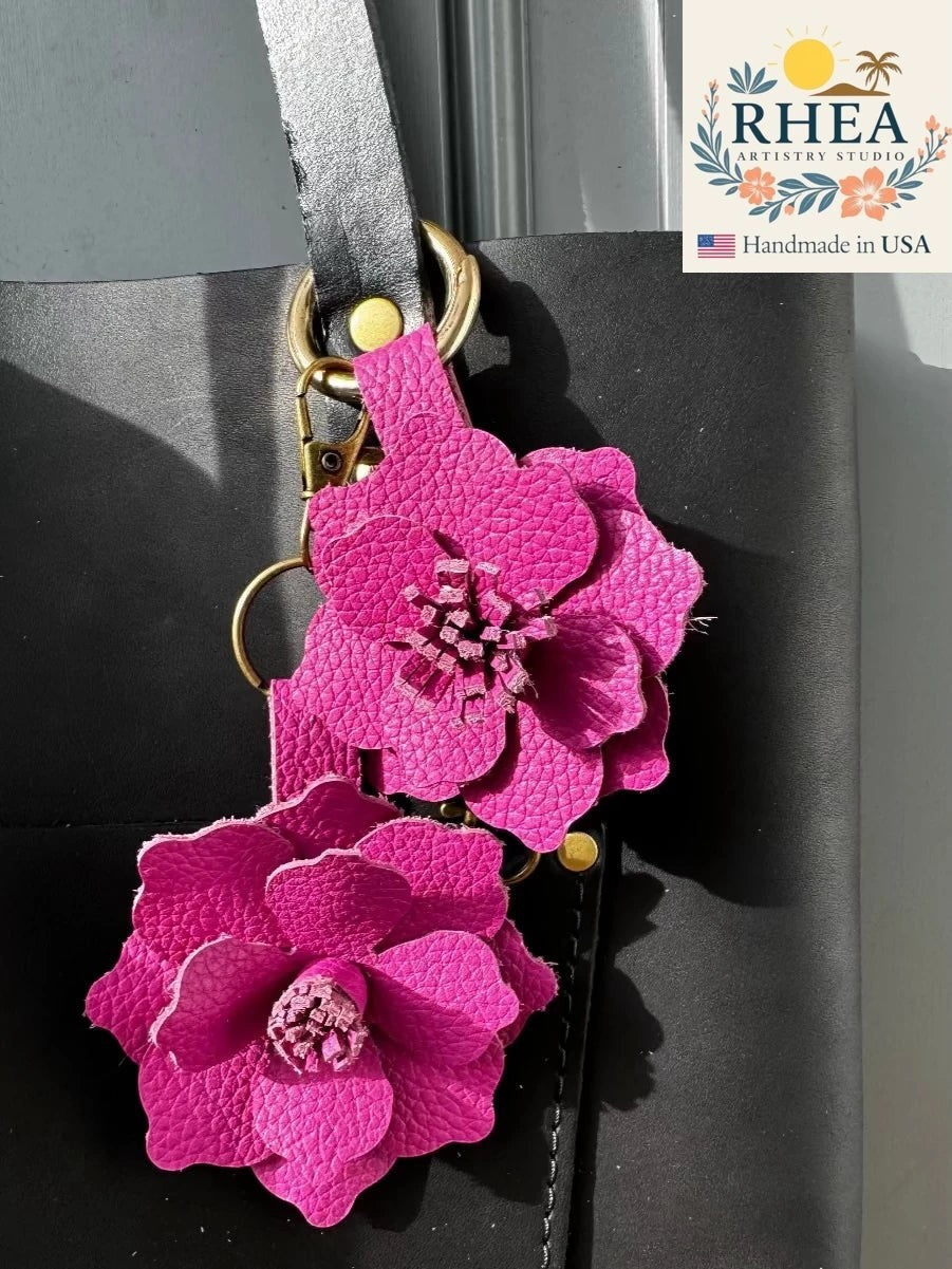 Rhea Artistry Studio pink leather flower charm with hibiscus and pink peacock hues, featuring a lobster clasp and split ring.