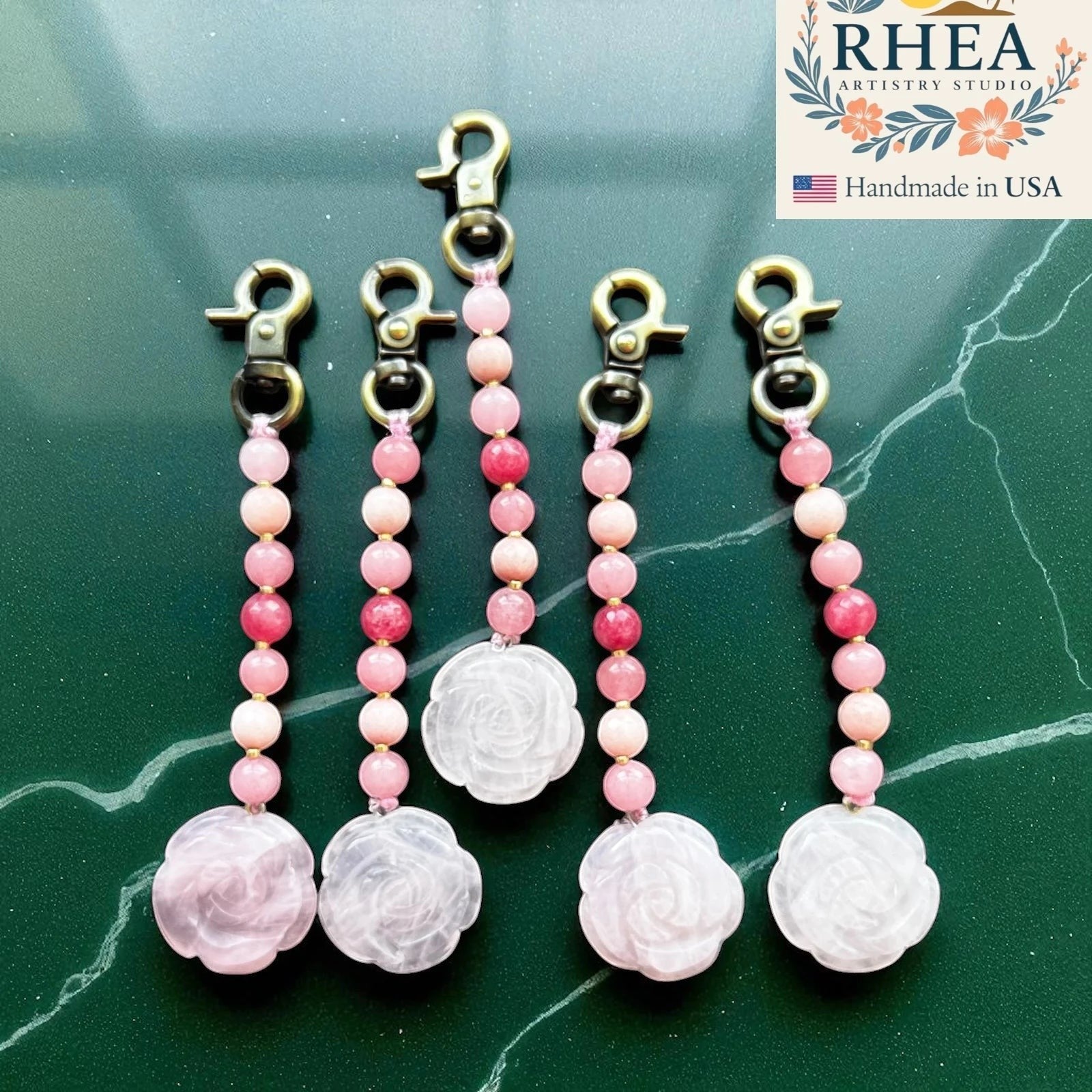 Rhea Artistry Studio pink rose quartz and agate beaded bag charm with brass clasp. Features a carved rose quartz pendant.