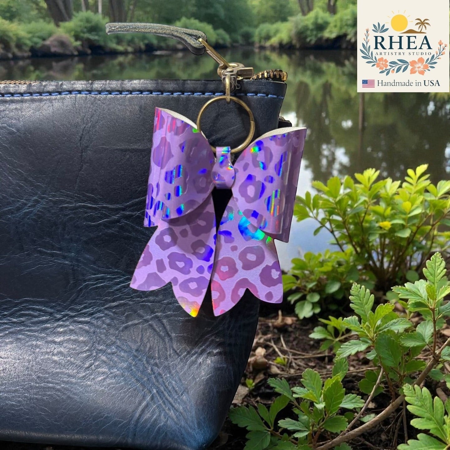 Rhea Artistry Studio purple holographic animal print bow bag charm with brass hardware.
