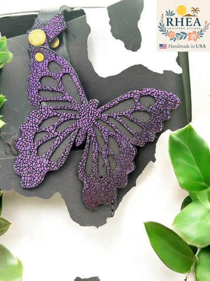 Rhea Artistry Studio purple iridescent leather butterfly charm with metallic finish and snap closure.