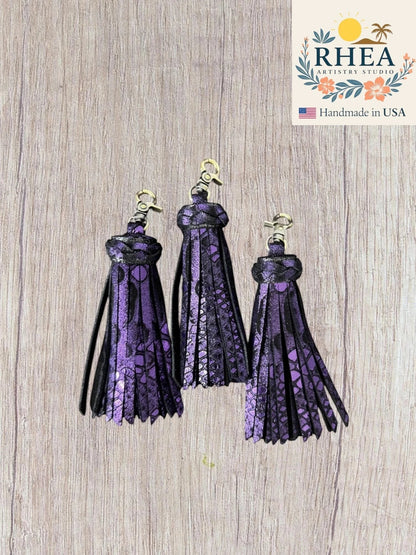Rhea Artistry Studio handmade purple and black leather tassel keychain with lobster clasp. Chunky, layered design with metallic finish.