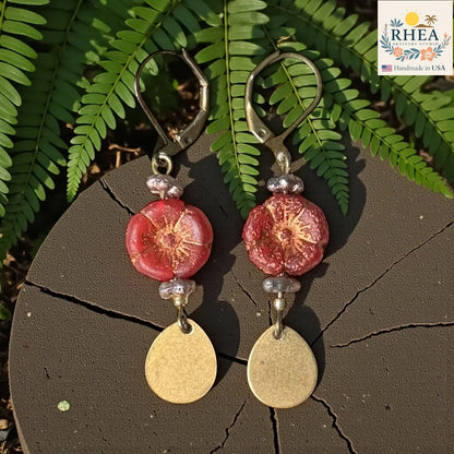 Rhea Artistry Studio red hibiscus glass bead drop earrings with brass teardrop charms and leverback hooks.
