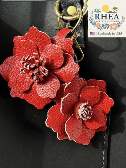 Rhea Artistry Studio red leather flower charm with detailed petals and a unique stamen, attached to a bag.