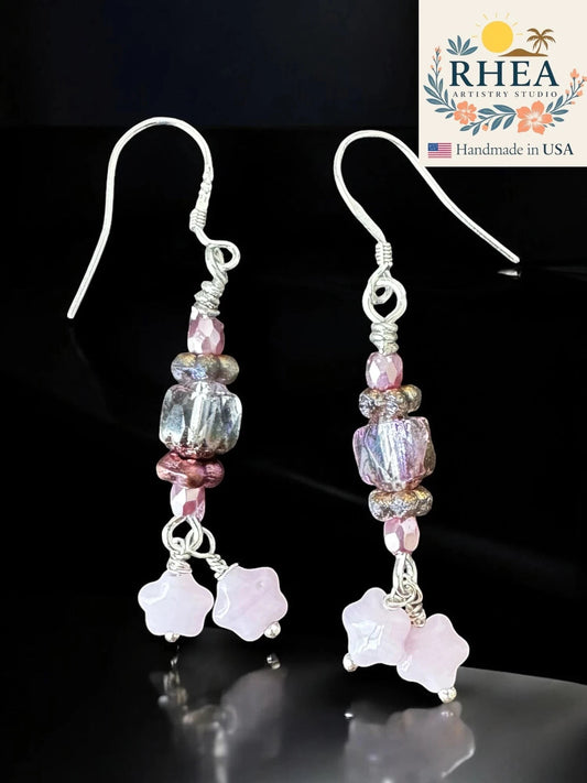 Rhea Artistry Studio rosé pink Czech glass bead earrings with iridescent finish and star accents, silver-plated French hooks, 1.75 inches long.