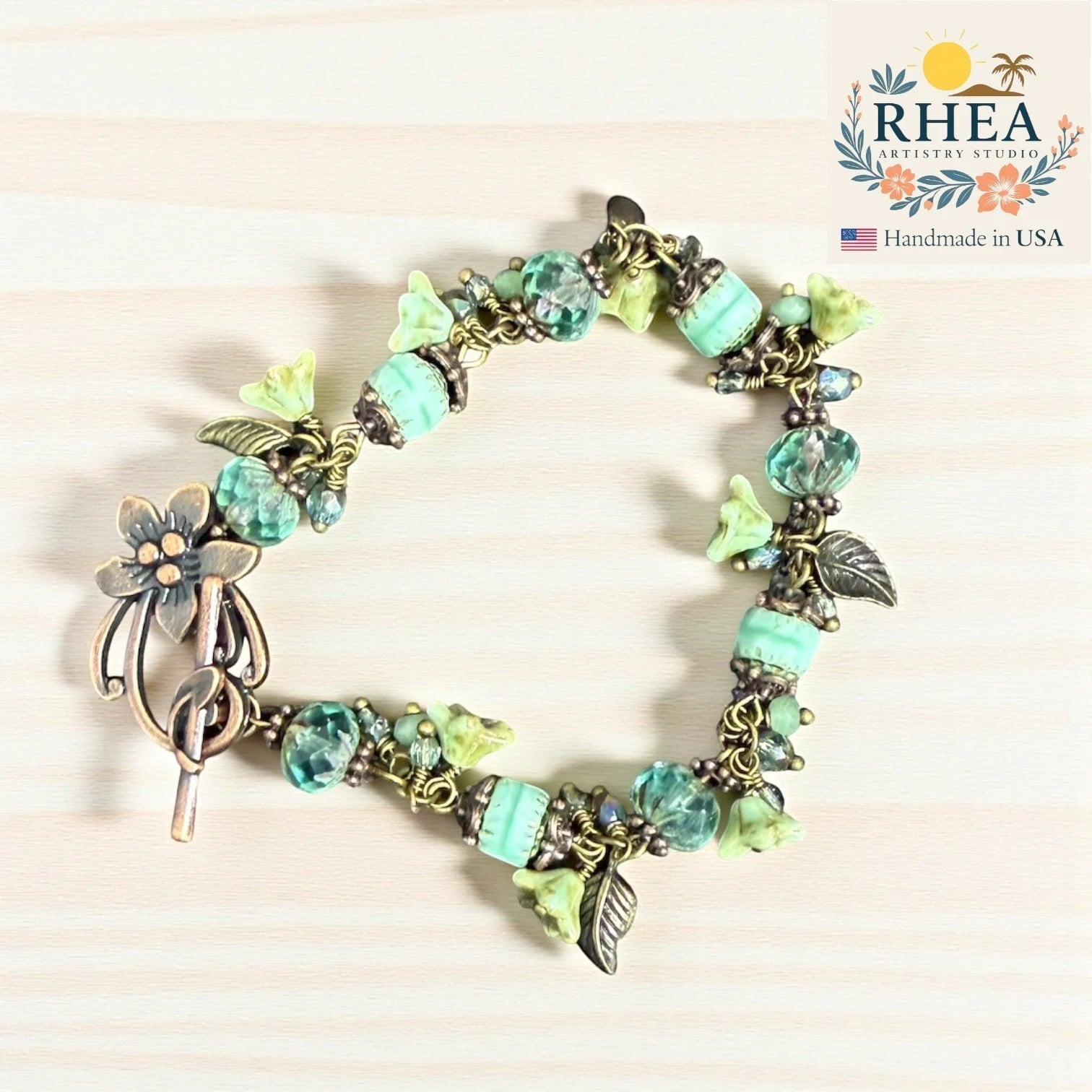 Rhea Artistry Studio sea glass bloom glass bead bracelet with floral toggle clasp and silver-toned accents.