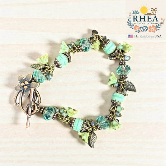Rhea Artistry Studio sea glass bloom glass bead bracelet with floral toggle clasp and silver-toned accents.