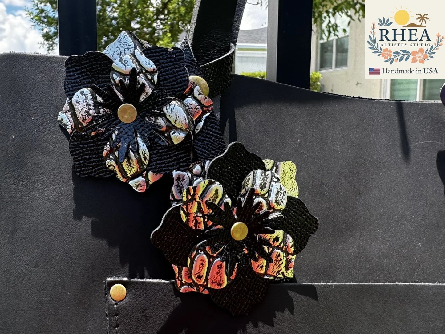 Rhea Artistry Studio double leather flower charm in silver and black, handcrafted from full-grain leather with brass rivets.
