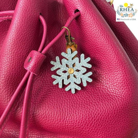 Rhea Artistry Studio glitter snowflake leather charm on a pink leather bag.