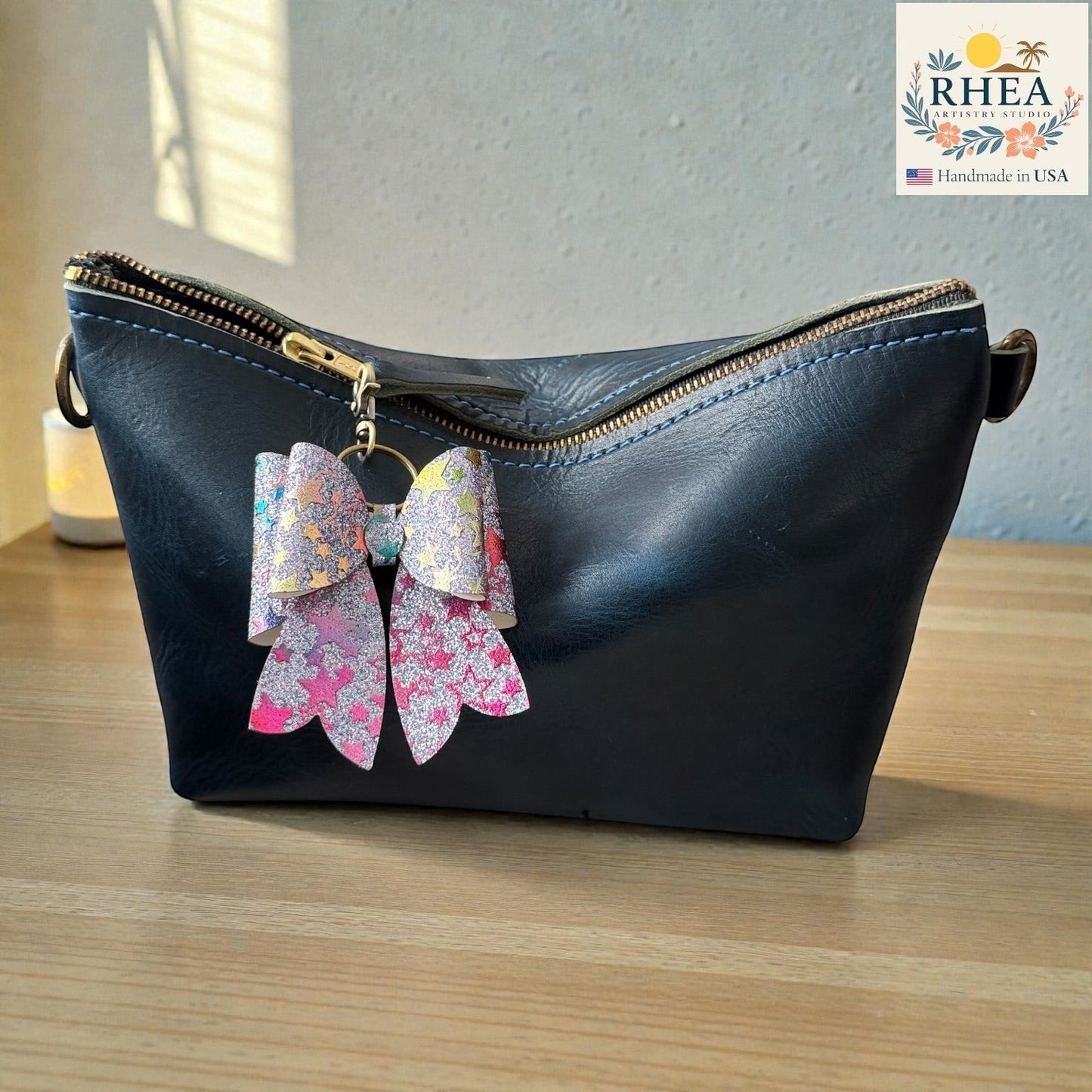 Rhea Artistry Studio handmade double-layer French bow bag charm with holographic star pattern and brass hardware.