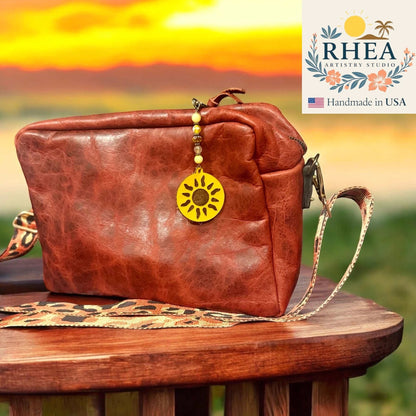 Rhea Artistry Studio sun charm bag accessory with yellow gemstone and Czech glass beads, and leather sun pendant.