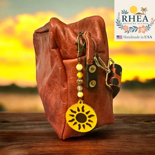 Rhea Artistry Studio handmade sun charm bag accessory with yellow gemstone and Czech glass beads, and leather sun pendant.