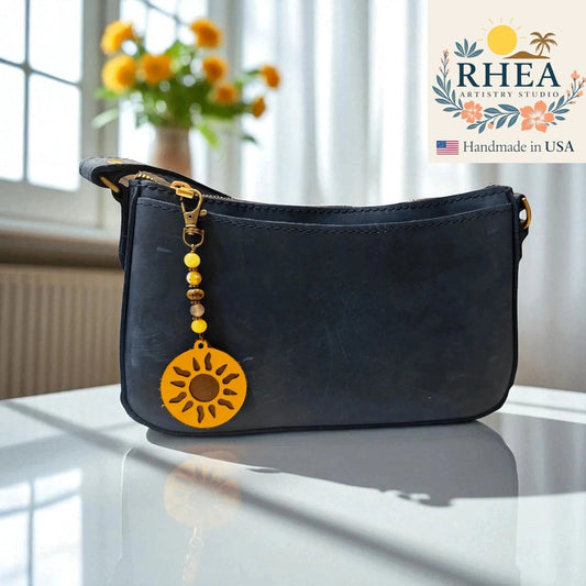 Rhea Artistry Studio handmade sun charm bag accessory with yellow gemstone and Czech glass beads, and leather sun pendant.