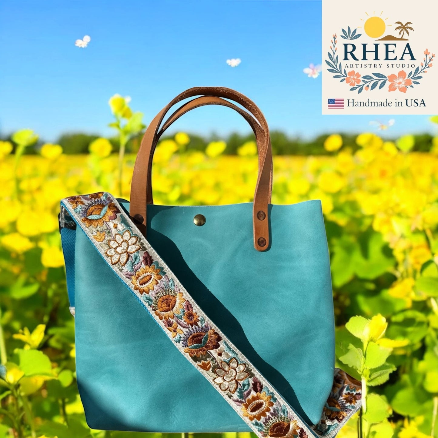 Rhea Artistry Studio teal leather tote bag with a 2-inch wide adjustable sunflower embroidered strap.