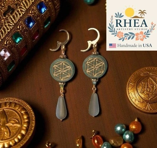 Rhea Artistry Studio teal glass coin earrings with flower of life design and pale blue teardrop beads. 24k gold plated brass.