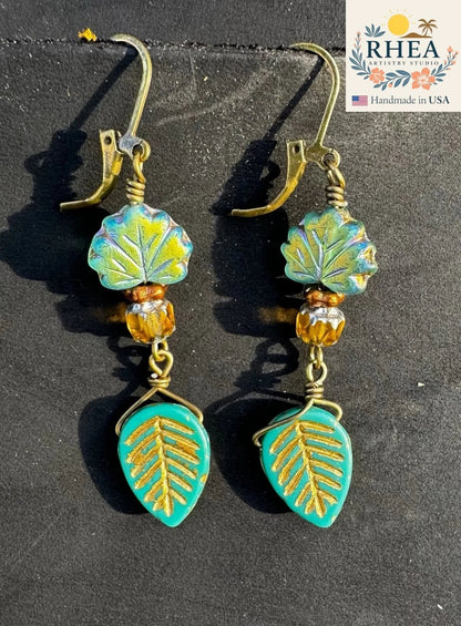 Rhea Artistry Studio handmade earrings with teal leaf charms and iridescent green leaf beads, brass hardware, 2 inches long.