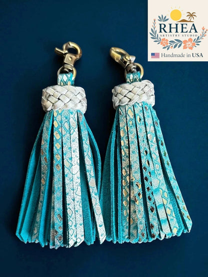 Rhea Artistry Studio handmade teal leather tassel keychain with metallic snake print accents and antique brass lobster clasp.