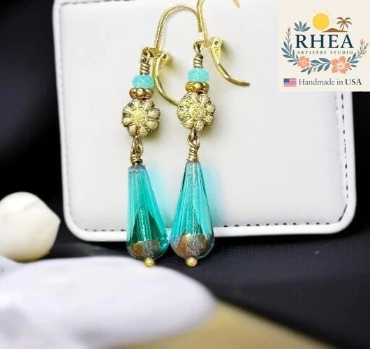 Rhea Artistry Studio long turquoise and gold glass drop earrings with dahlia accent and brass hardware.