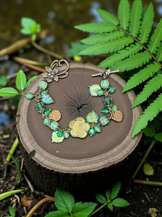 Rhea Artistry Studio Verdant Bloom bracelet with green agate and glass beads, floral motifs, and antique-toned toggle clasp.