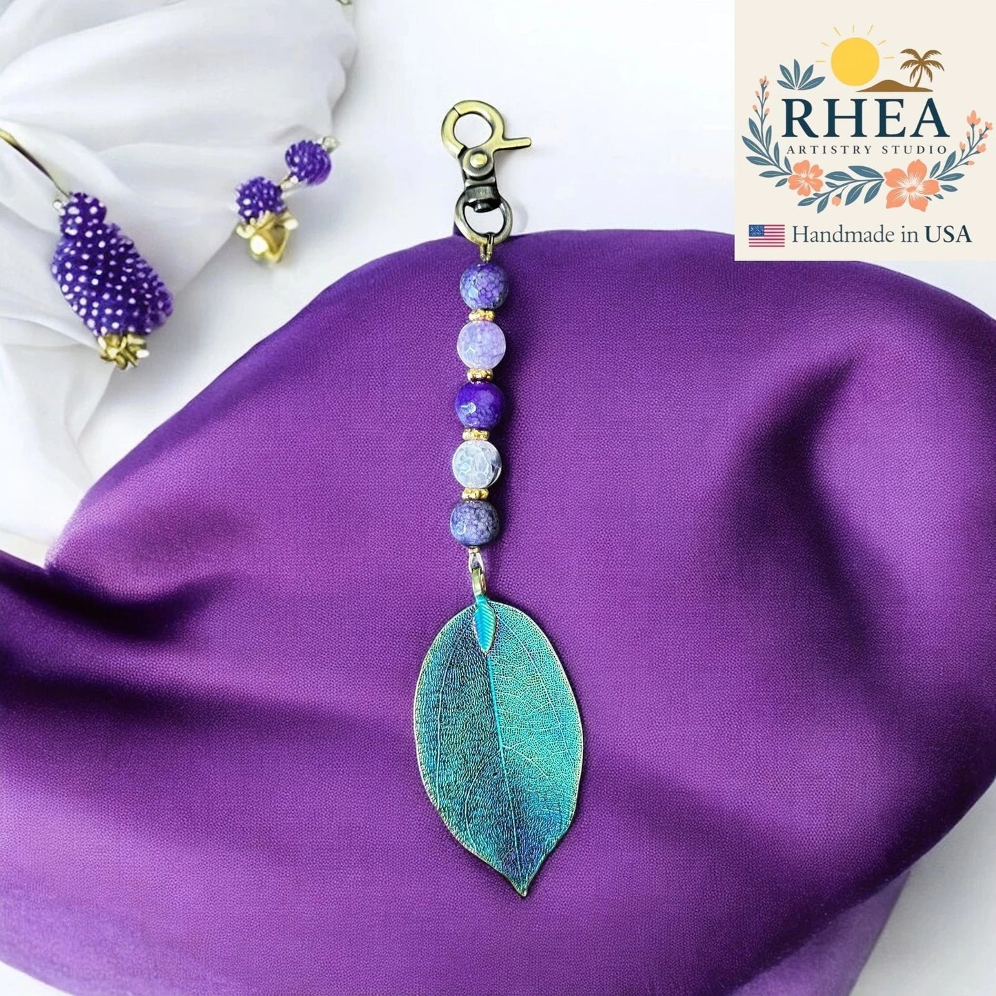 Rhea Artistry Studio handmade violet gemstone bag charm with electroplated natural leaf pendant and gold clasp.
