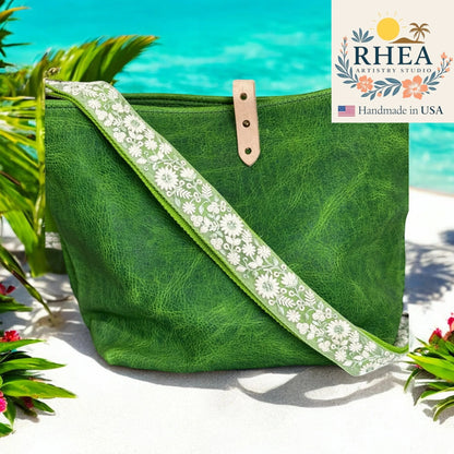 Rhea Artistry Studio green leather crossbody bag with a 1.5-inch adjustable strap featuring white wildflower embroidery.