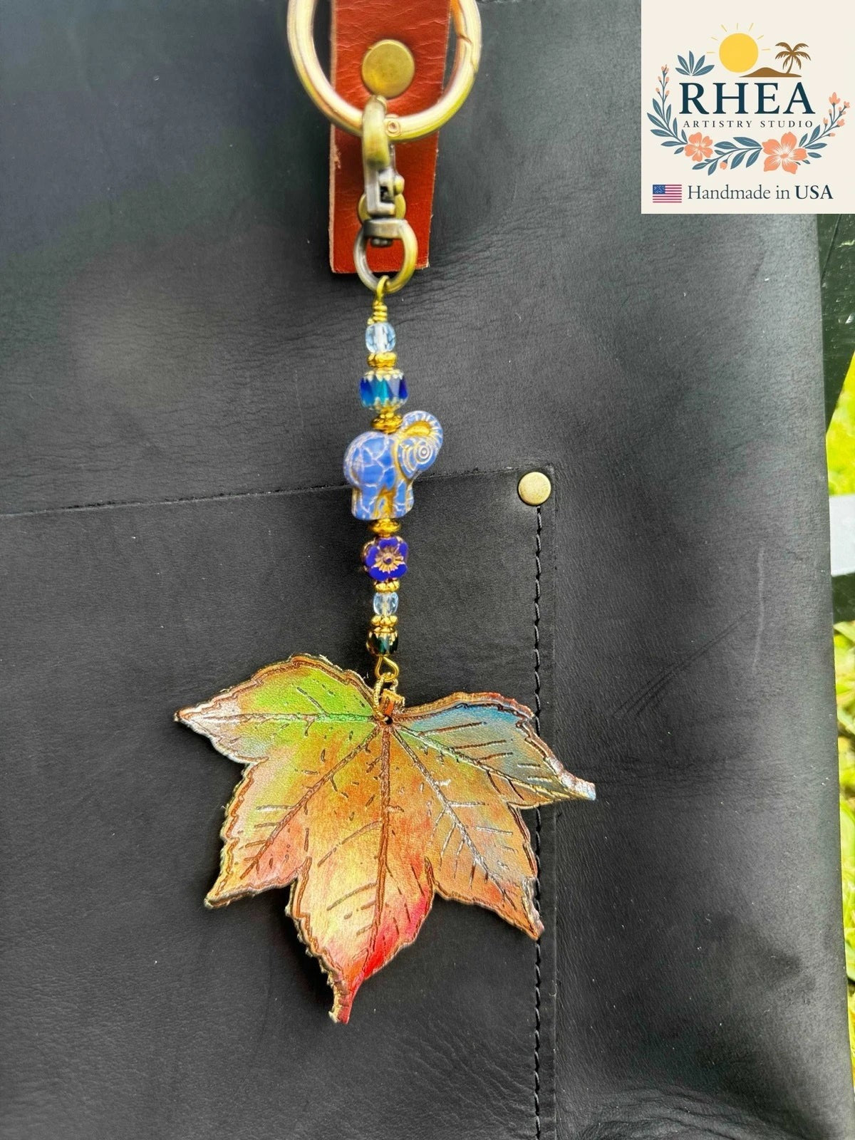 Rhea Artistry Studio Woodland Twilight leather charm with maple leaf, blue elephant bead, and Czech glass beads on brass hardware.