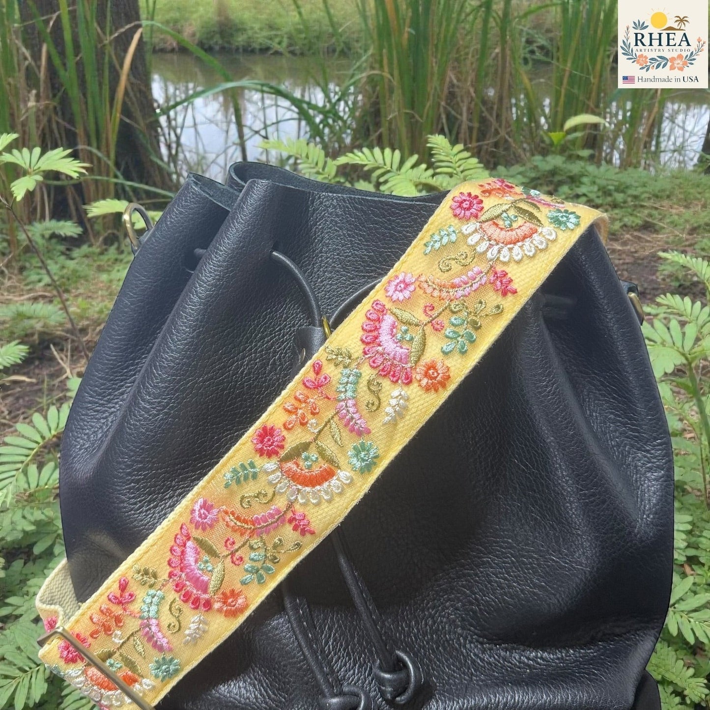 Rhea Artistry Studio yellow crossbody strap with floral embroidery in pink, orange, and green, 2-inch width, adjustable 30-54 inches.