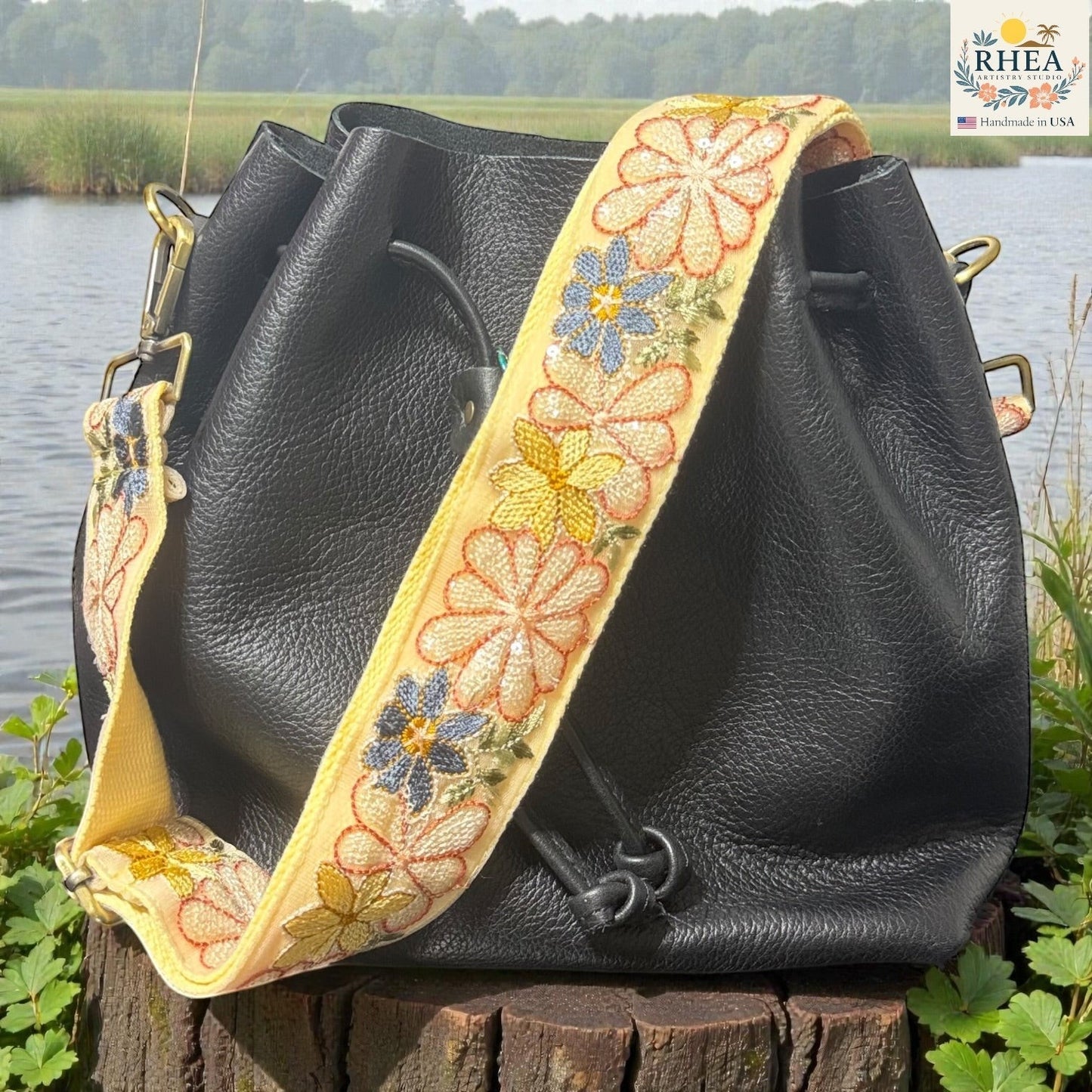 Rhea Artistry Studio yellow embroidered crossbody strap with daisies and blue flowers, 2-inch wide, adjustable 30-54 inches.