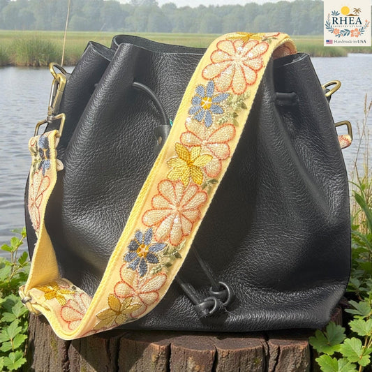 Rhea Artistry Studio yellow embroidered crossbody strap with daisies and blue flowers, 2-inch wide, adjustable 30-54 inches.
